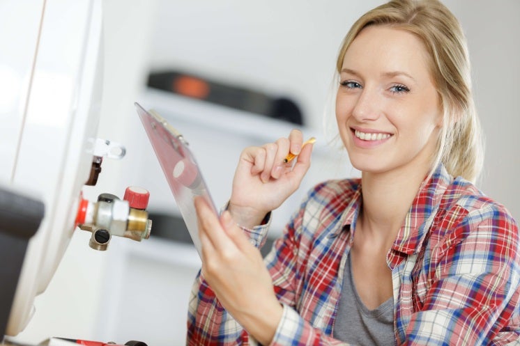 woman looks at camera as she's installing a boiler