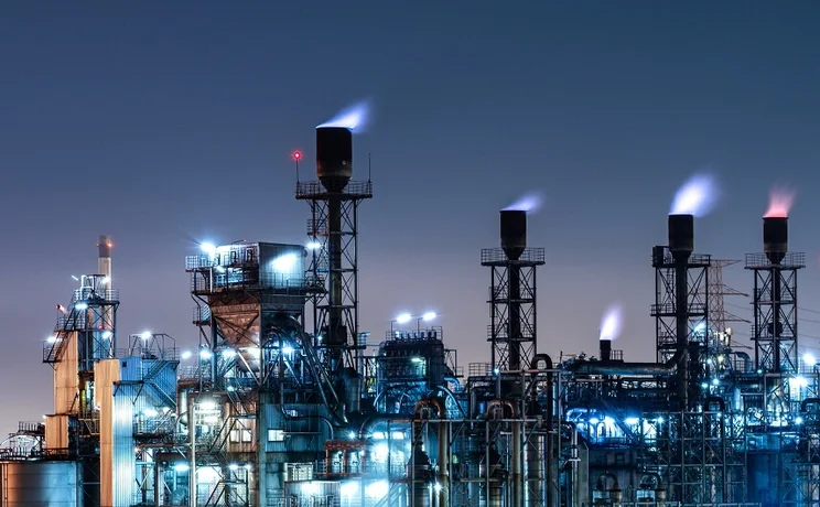 Industrial gas refinery at night, with visible burn-off