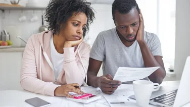 couple looking sad at their bills