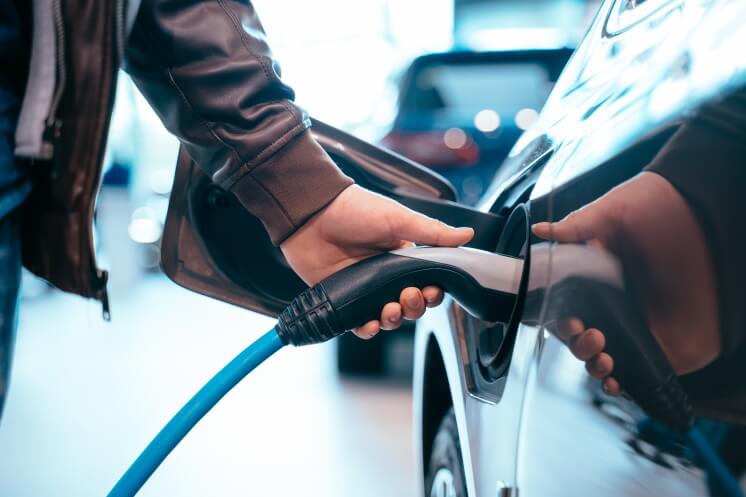 person charging electric car