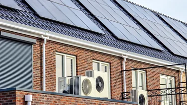 A row of houses with heat pumps and solar panels