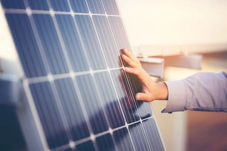Close up of engineer's hand touching a solar panel