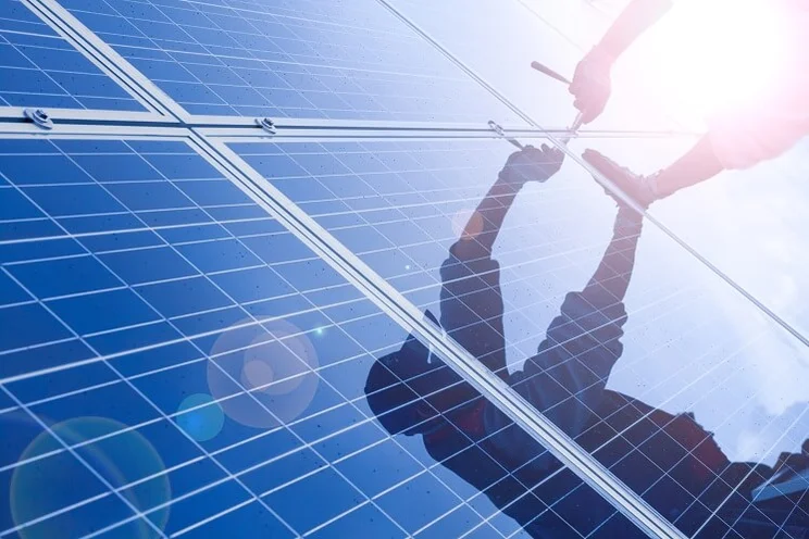 close up of man's hands installing solar panels
