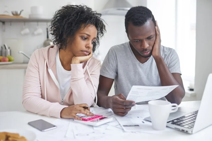 couple looking sad at their bills