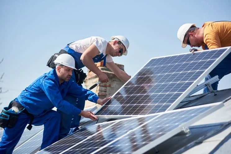 solar panel installers on a roof