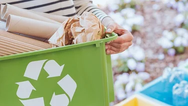 A woman carrying recycling box