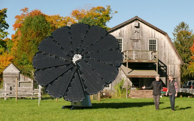 A SmartFlower installed on a field outside a barn