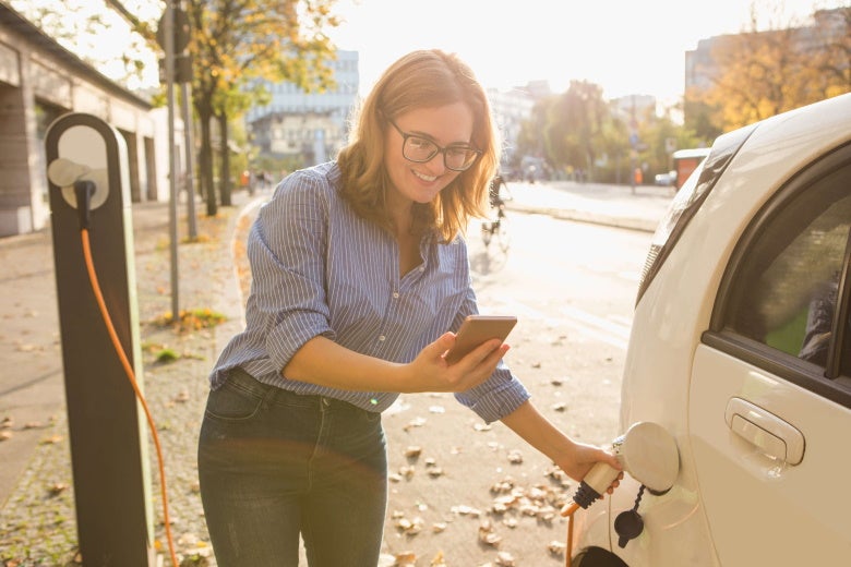 woman charging electric vehicle