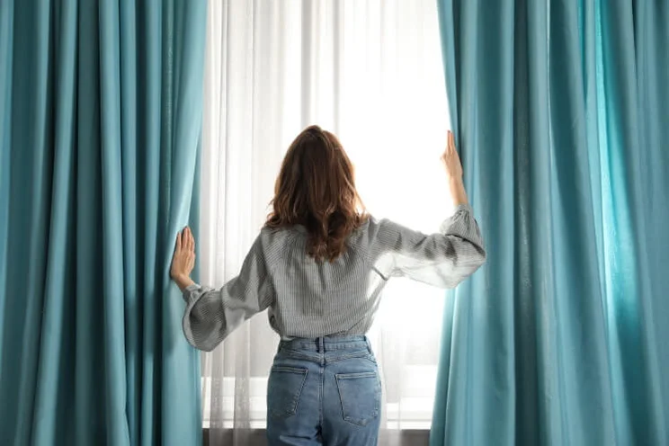 woman in front of curtains