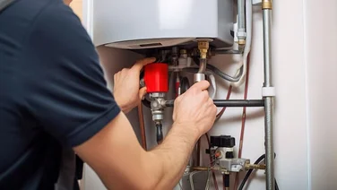 technician fixing pipes under a water heater