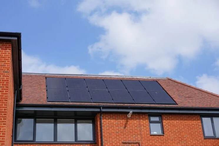 house with visible bricks and solar panels on the roof
