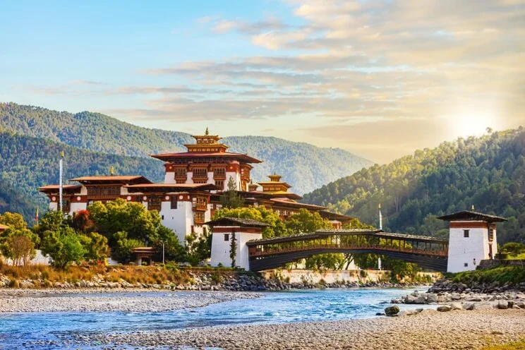 Punakha Dzong, an administrative centre, at the Mo Chhu river in Bhutan, in front of a river and set against mountains