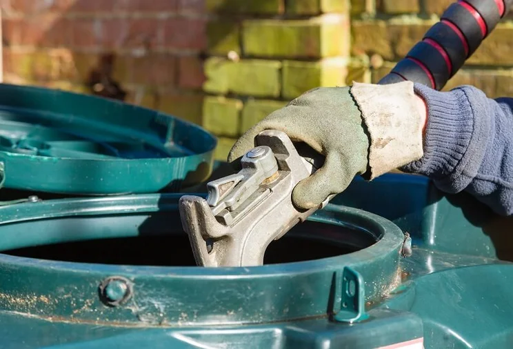 Close up of a person filling an oil tank with heating oil