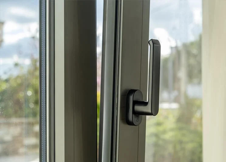 A close up view of a handle on an aluminium tilt and turn window