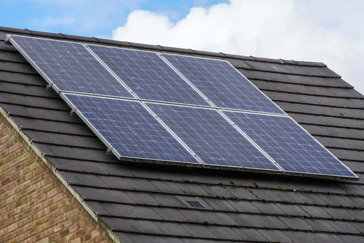 House with solar panels on the roof, against the sky