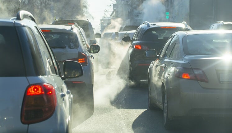 cars releasing emissions on road