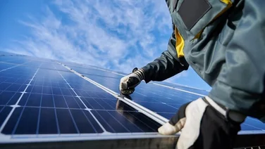 Close up photo of someone installing solar panels from a low angle