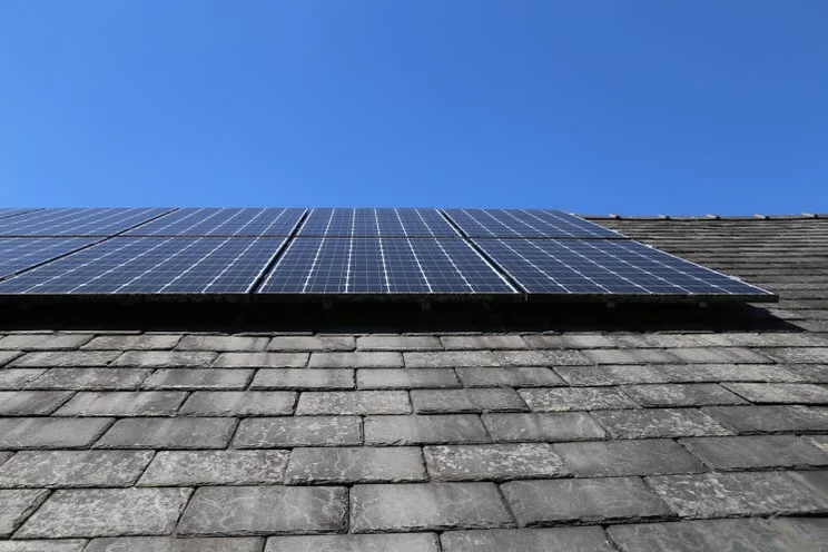 solar panels on a slate roof in Wales, under a blue sky