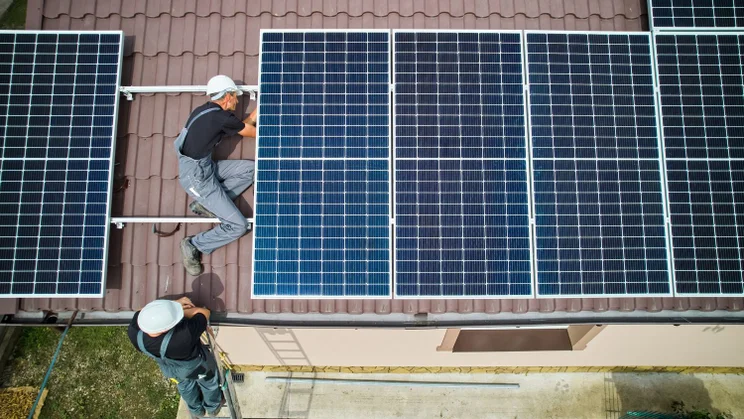 People installing solar panels on a roof