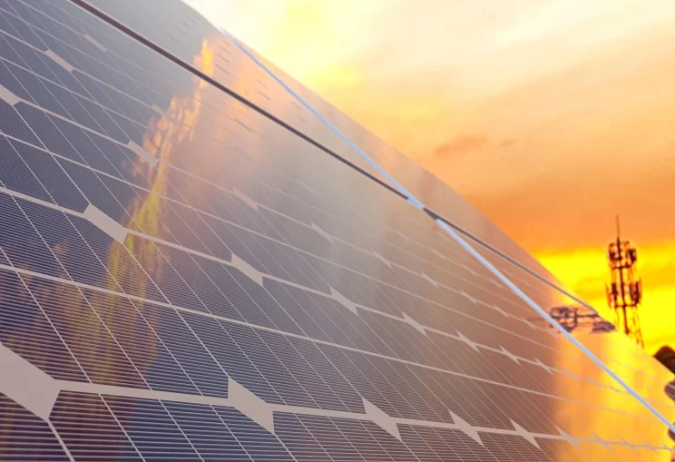 solar panels set against an orange sky