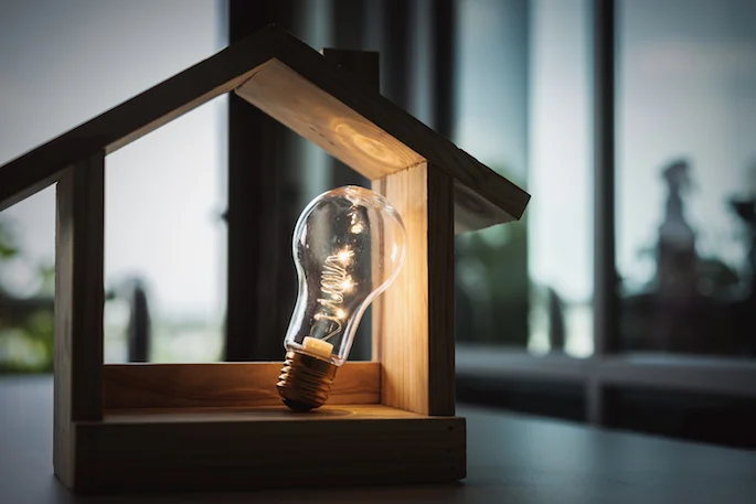lightbulb inside a model wooden house