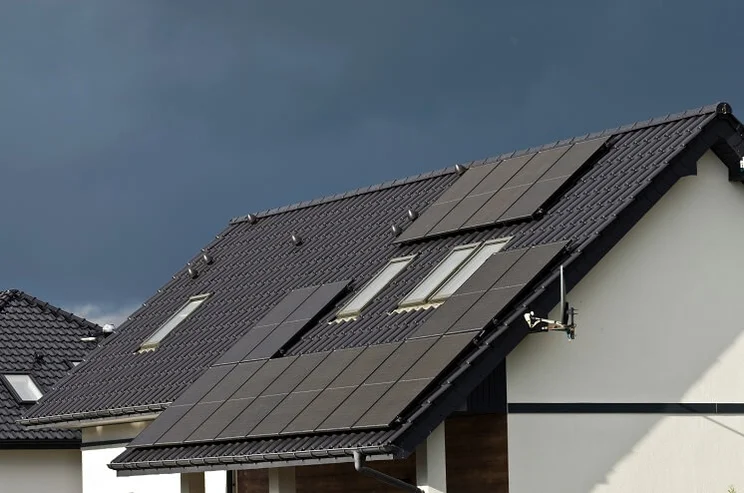 solar panels on roof of house with dark clouds in background