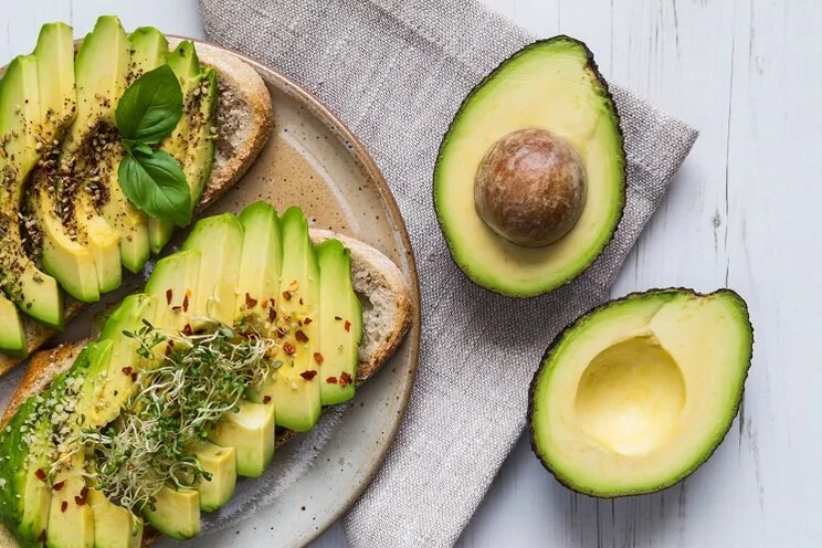 Sliced avocados on toast on a stoneware plate