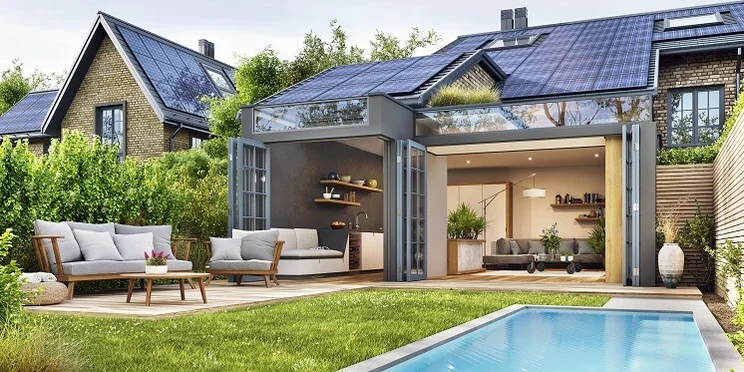 A house with solar panels on the roof open patio with sofas on it and a swimming pool