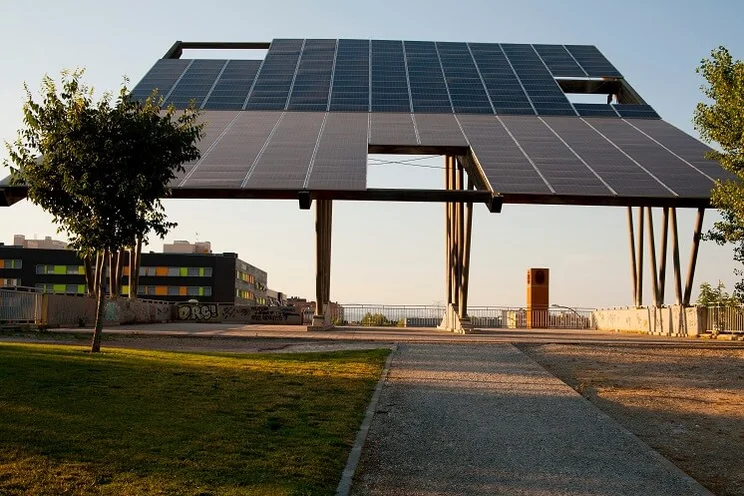 solar panel pergola in parking lot with office buildings in background