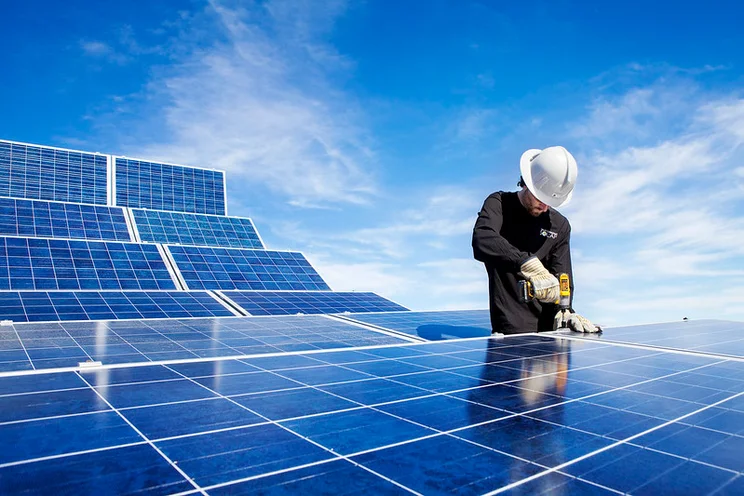 Workman installing solar panels.