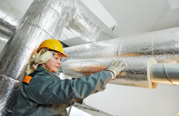 woman fitting pipe insulation