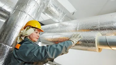 woman fitting pipe insulation