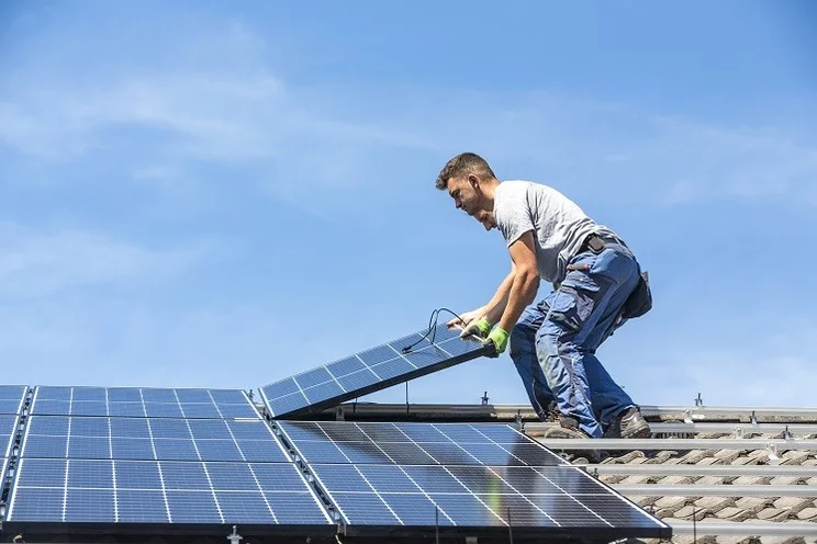 man installs a solar panel system