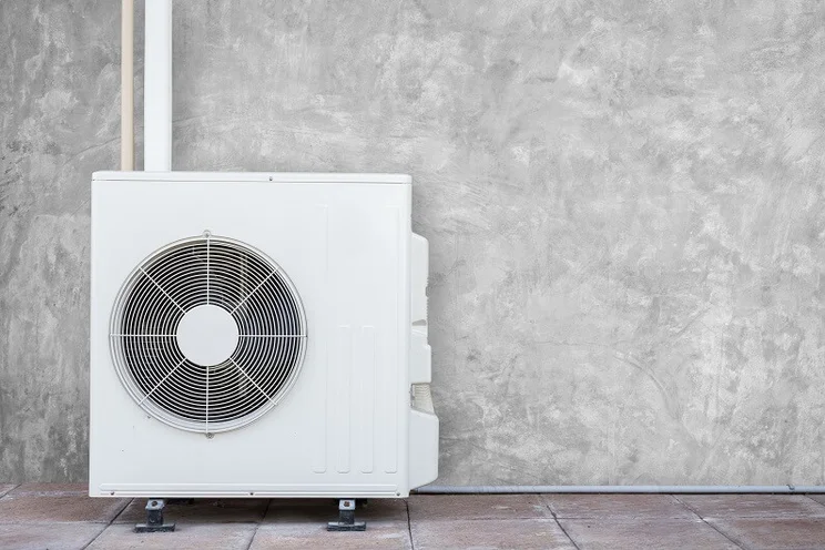 Heat pump against grey wall