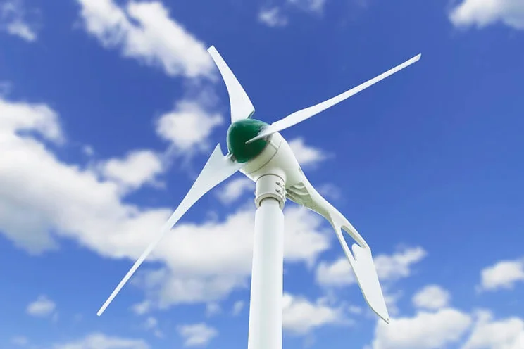 Standalone residential wind turbine with a blue sky background and scattered clouds