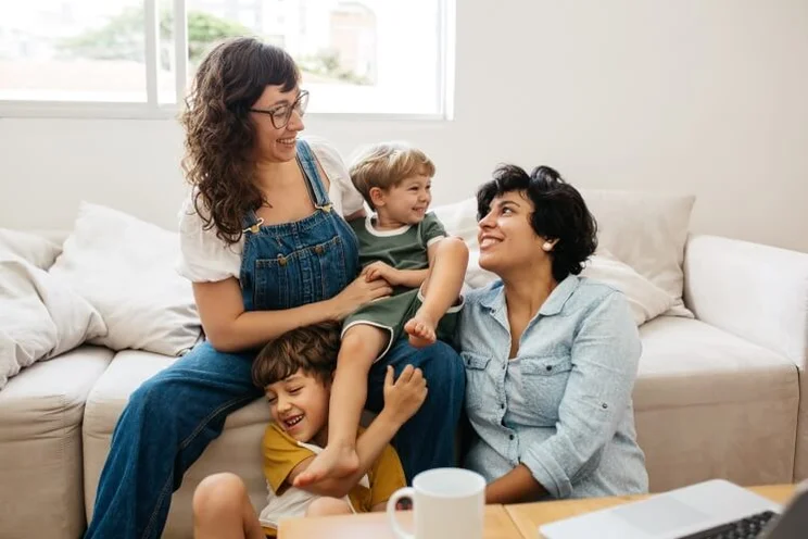 family hugging on a sofa