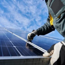 Close up photo of someone installing solar panels from a low angle