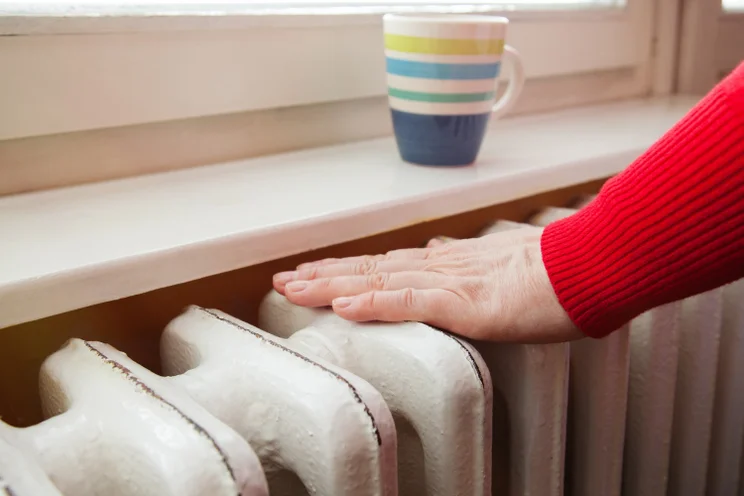 A hand touching a radiator