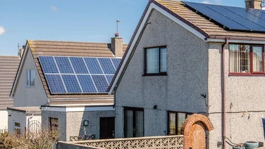 Roof Mounted Solar Panels in Holyhead, Wales. There is a clear blue sky in the background.