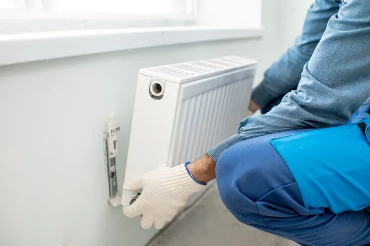 installer removing radiator from the wall