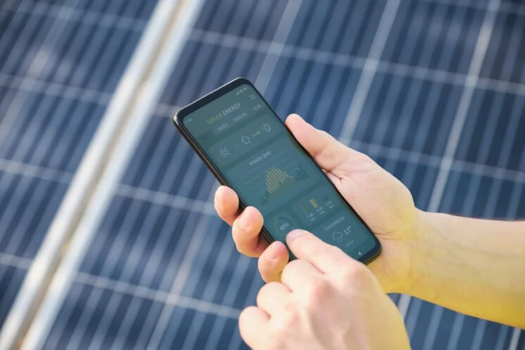 Someone monitoring solar panel performance on a mobile app