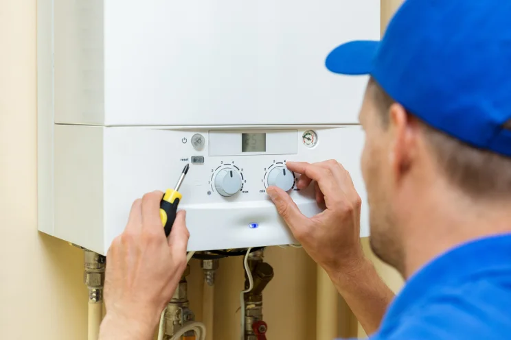 Man adjusting a gas boiler
