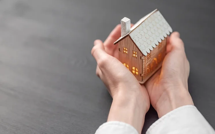 Woman holding a miniature house, insulated concept