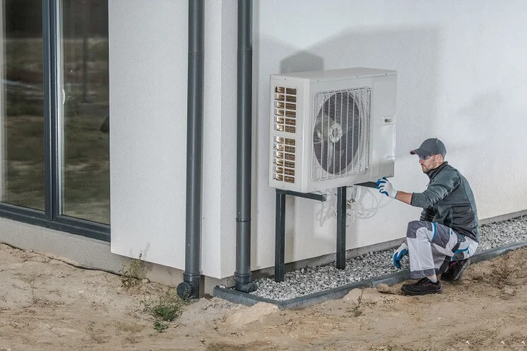 Engineer fixing an air source heat pump