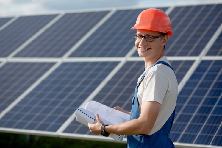 man stands in front of solar panels