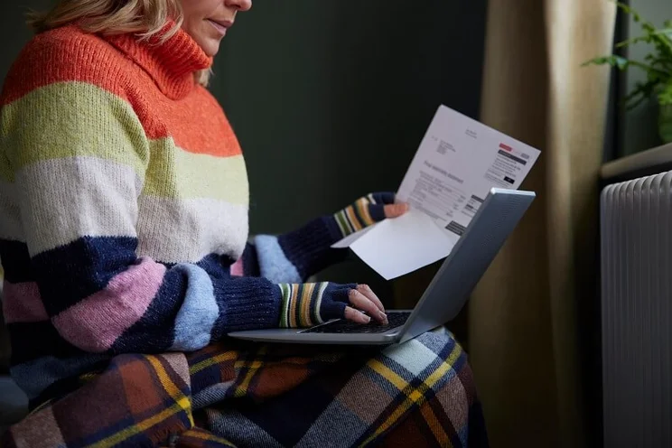 Woman looking at her bills holding a calculator