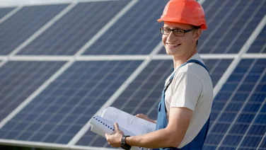 man stands in front of solar panels