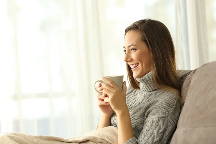 Lady in a warm house with a cup of tea
