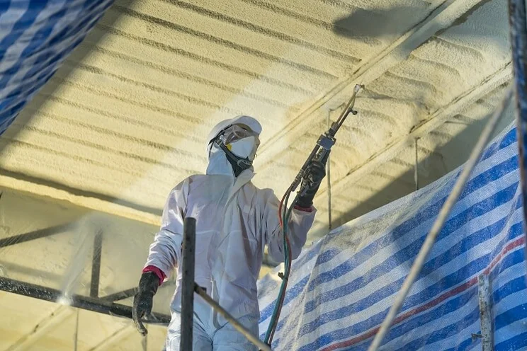 someone installing spray foam insulation