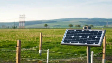 solar panel on fence with grass fields and hills on background